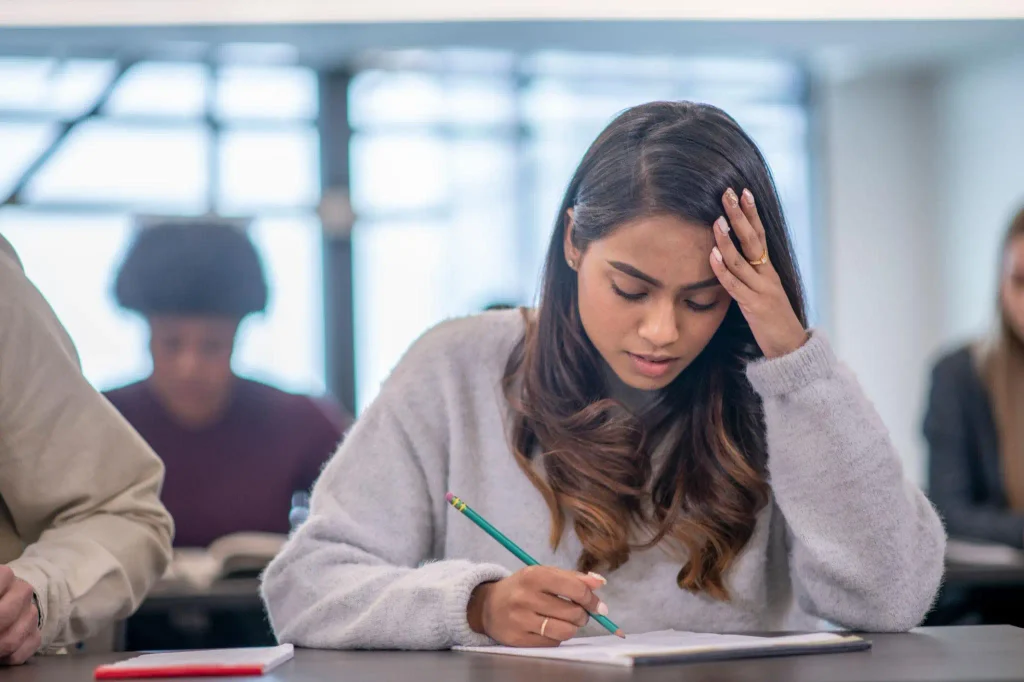 Un étudiant concentré en salle de classe appliquant des techniques pour gérer le stress des examens